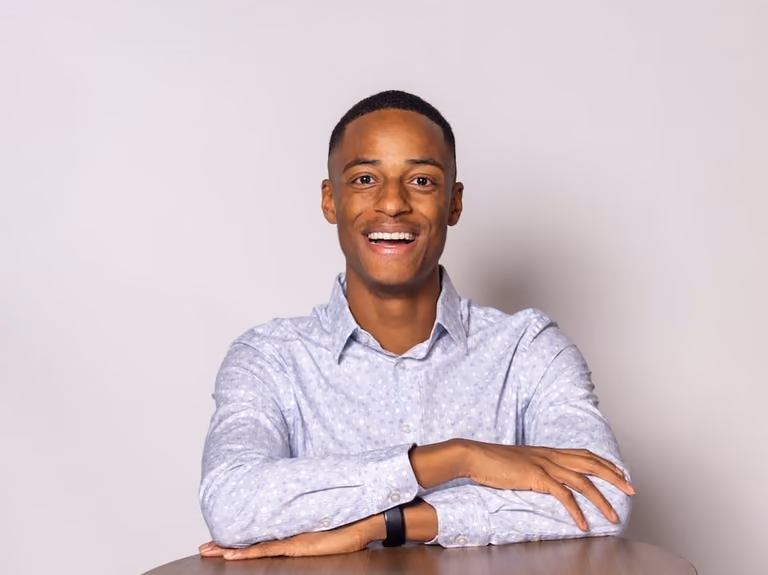Portrait of Austin Akers, smiling in a light patterned shirt